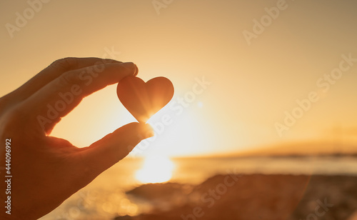 Heart against beautiful nature sunset. Love symbol  photo
