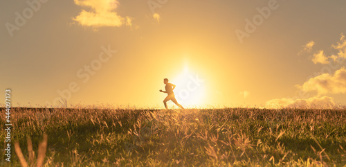 Man running jogging in a grass field. Health and fitness concept. 