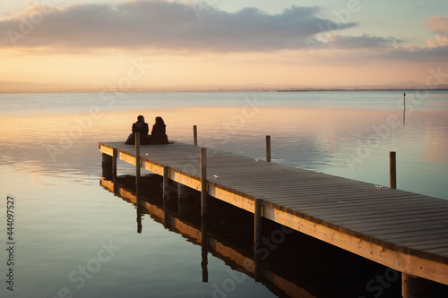 A romantic couple sitting in the dock photo