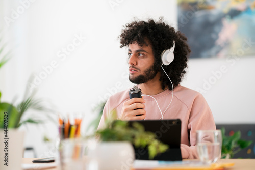 Arab man using audio recorder in studio photo