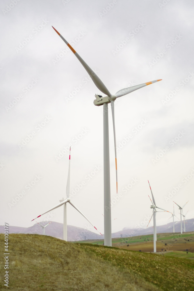 Fototapeta premium Electricity Wind turbine landscape. Wind farm energy eco friendly in mountains. Renewable clean energy production. Vertical photo