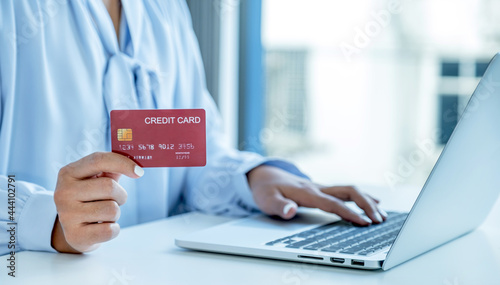 Consumer woman hand holding a mock up credit card, Ready to spending pay online finance shopping according to discount products via laptop from home office