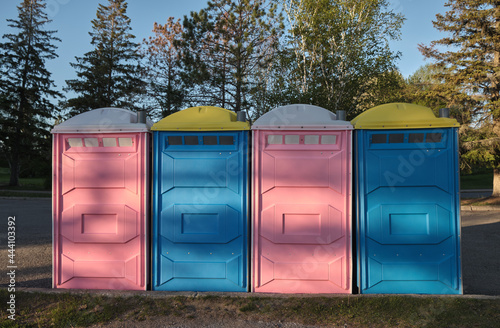 Pink and Blue Portable Toilets in Row 