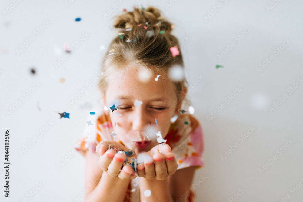 Blond girl blowing confetti off her hands Stock Photo Adobe Stock