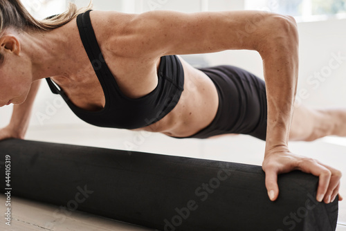 Crop athletic woman doing push ups during training photo