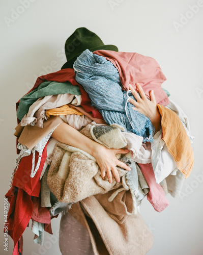 Person with a mountain of clothes in her hands photo