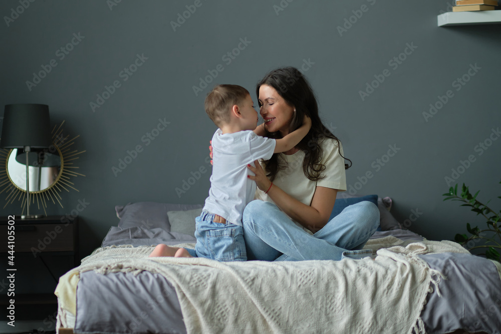 mother hugs with her toddler little son on a bed together. Family moments, children care. Motherhood, maternity leave concept mother hugs with her toddler little son on a bed together. Family moments, children care. Motherhood, maternity leave concept