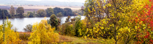 Golden autumn. Autumn landscape with colorful plants by the river  panorama