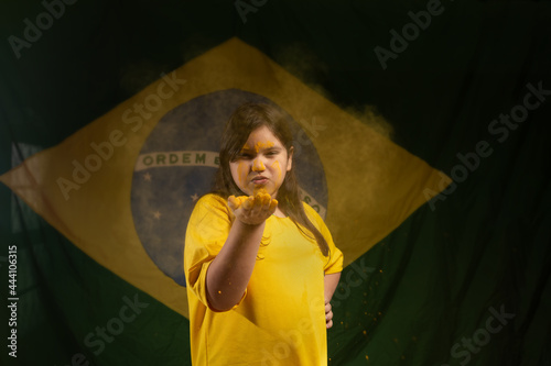 child smiling with the brazil flag in the background