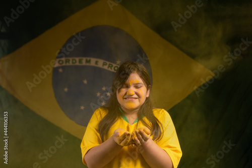 child smiling with the brazil flag in the background