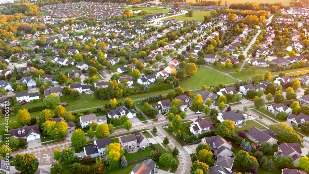Beautiful neighborhoods, homes in Summertime aerial drone view at sunset.
