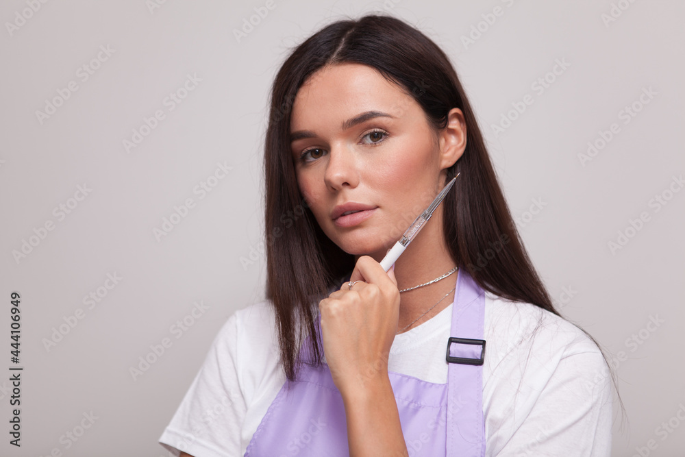 Close up portrait of a beautiful woman holding nail paint brush Close up portrait of a beautiful woman holding nail paint brush