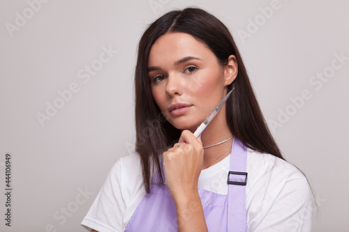 Close up portrait of a beautiful woman holding nail paint brush