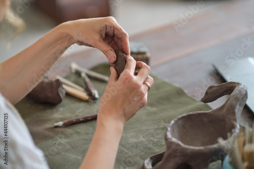 Potter female kneads a piece of clay with her hands in her Studio workshop. Pottery made of clay with their own hands.