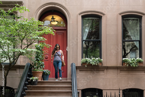 Woman leaving brownstone apartment building