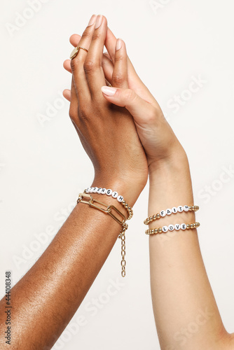 Two female hands with jewelry on holding each other