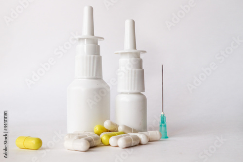 medicines, drops in plastic bottles, tablets on a white background