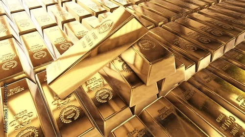 Gold bricks. Stack of gold bullion bars. Seamless looping footage. Gold bars stacked in a row. The camera pans around gold bars in close up.