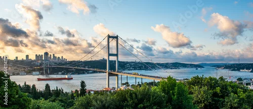 Obraz  z motywem ISTANBUL, TURKEY. Panoramic view of Istanbul Bosphorus on sunset. Istanbul Bosphorus Bridge (15 July Martyrs Bridge. Turkish: 15 Temmuz Sehitler Koprusu). Beautiful cloudy blue sky.
