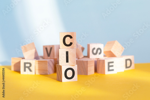 CIO written on wooden cubes, yellow background