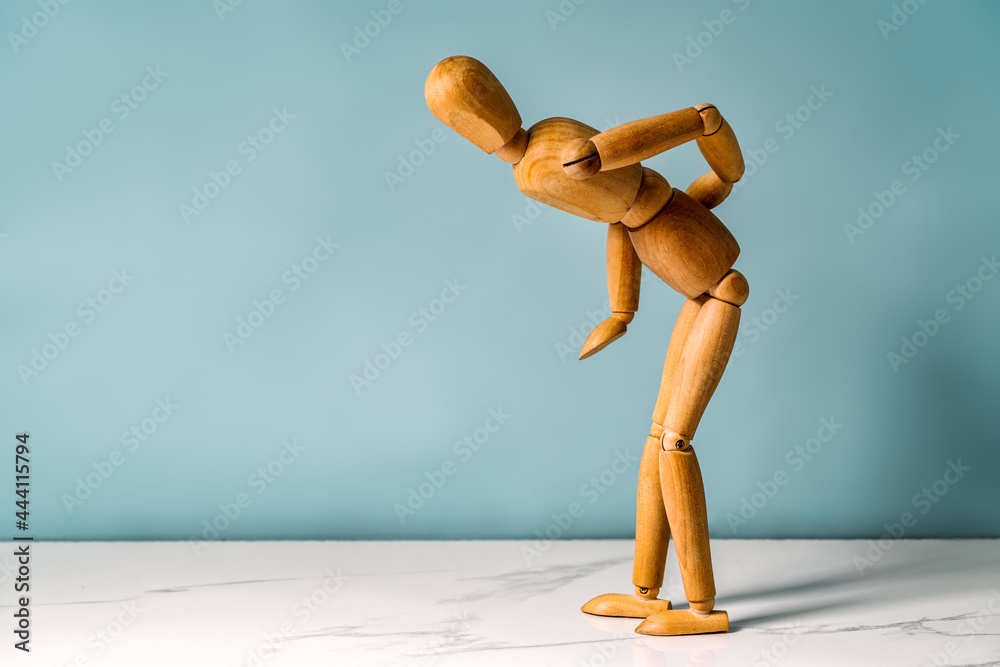 Concept of back pain. A wooden figure depicts a pain in the back.