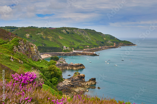 Image of Bouley Bay fromadjacent cliff paths. with cloudy sky and calm sea. Jersey, Channel Islands photo