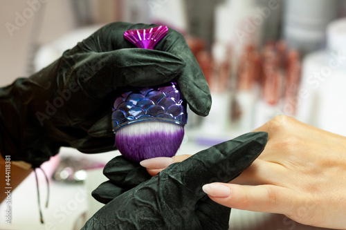 Obraz na płótnie Nail stylist removing dust from nails w salonie