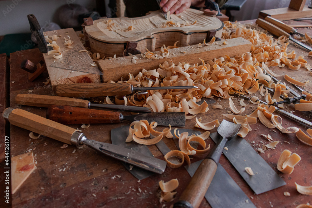Luthier's hands using gouge to work the wood and make a violin Stock ...