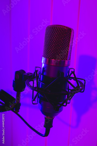 Close the studio condenser microphone with antivibration support real-time with blue and red backlight. Zoomed view, close-up.