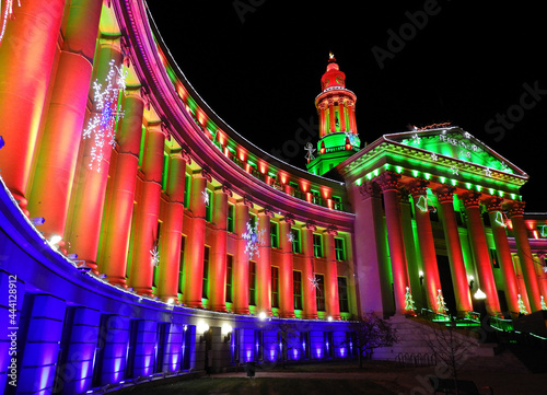 the very colorfully-illuminated  denver city and county building on christmas eve in denver, colorado