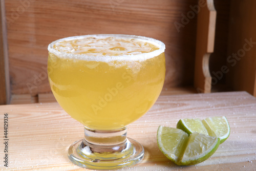 delicious and refreshing alcoholic drink with citrus fruits, margarita, cozumel on a table in a glass cup on the dark background photo