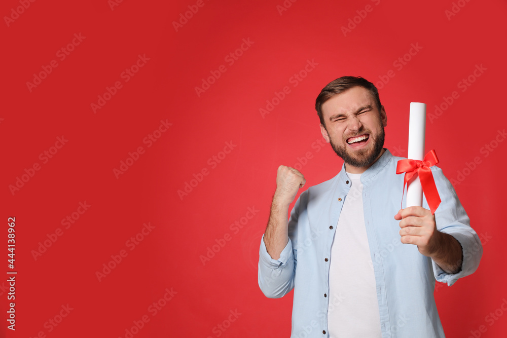 Emotional student with diploma on red background. Space for text Emotional student with diploma on red background. Space for text