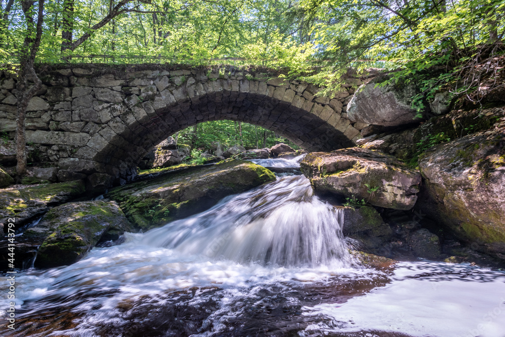 Old stone bridge over waterfalls in the forest woods Old stone bridge over waterfalls in the forest woods