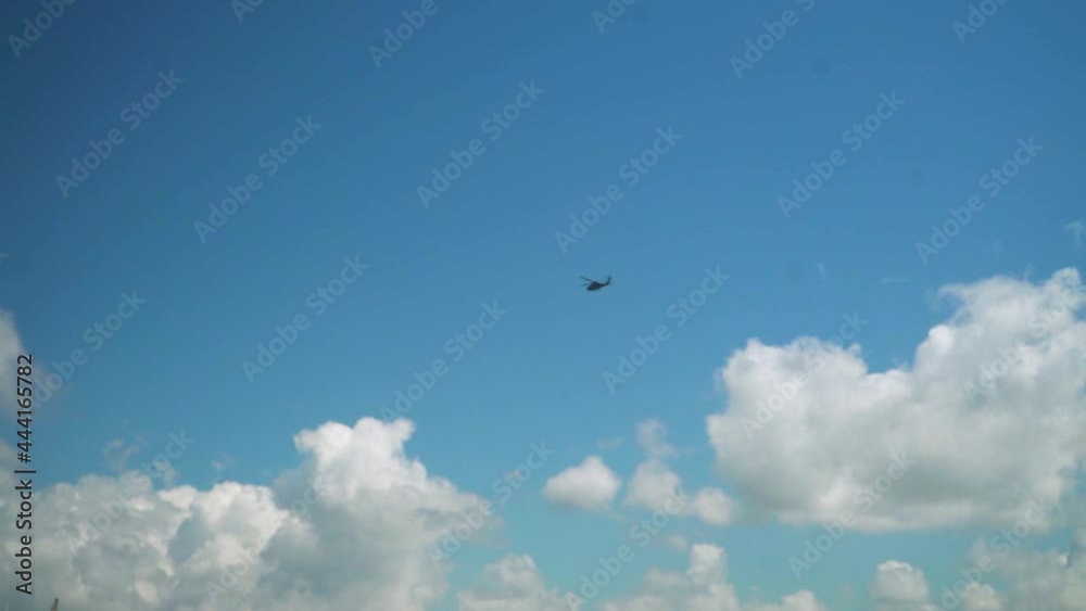 Image following a flying Heli in the blue sky from far away Image following a flying Heli in the blue sky from far away