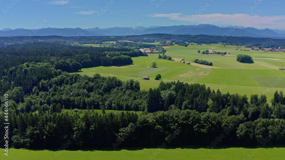 Smooth drone flight over green meadows and a little lake with the aerial view at the alp mountains - idyllic place and a recreation background video in 4k