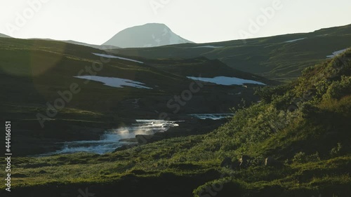 mountain stream flows down on Stekenjokk fields, during sunset hour. Northern Sweden, summer arrival photo