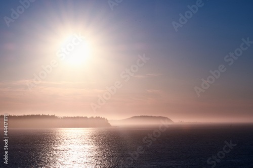 Sunset over islands shrouded with mist © Andy