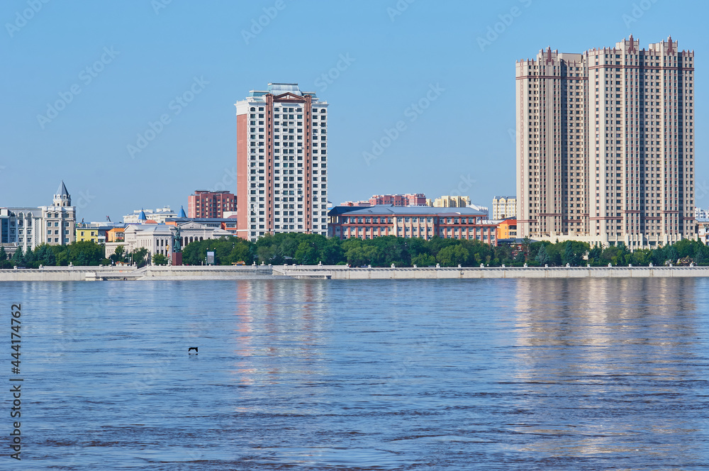 Obraz premium View of the embankment of the neighboring town of the neighboring country from the city of Blagoveshchensk, Russia. Flood period.