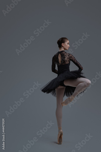 Rear view of ballerina wearing dress dancing inside studio