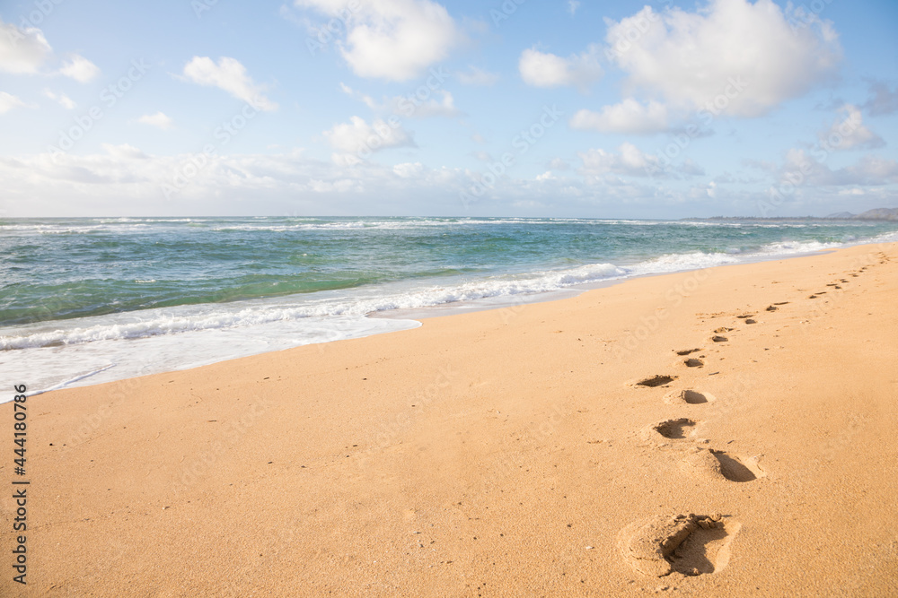 Foot prints on sand by ocean