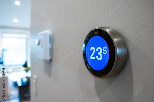 Google Nest Hub mounted on wall showing digital thermometer.