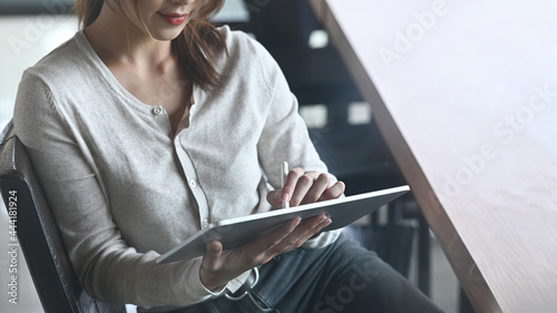 Businesswoman sitting in office and working with digital tablet.
