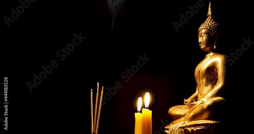 Stop motion photo,Burning incense and candles to pay homage to the Buddha image , black background,floating incense smoke