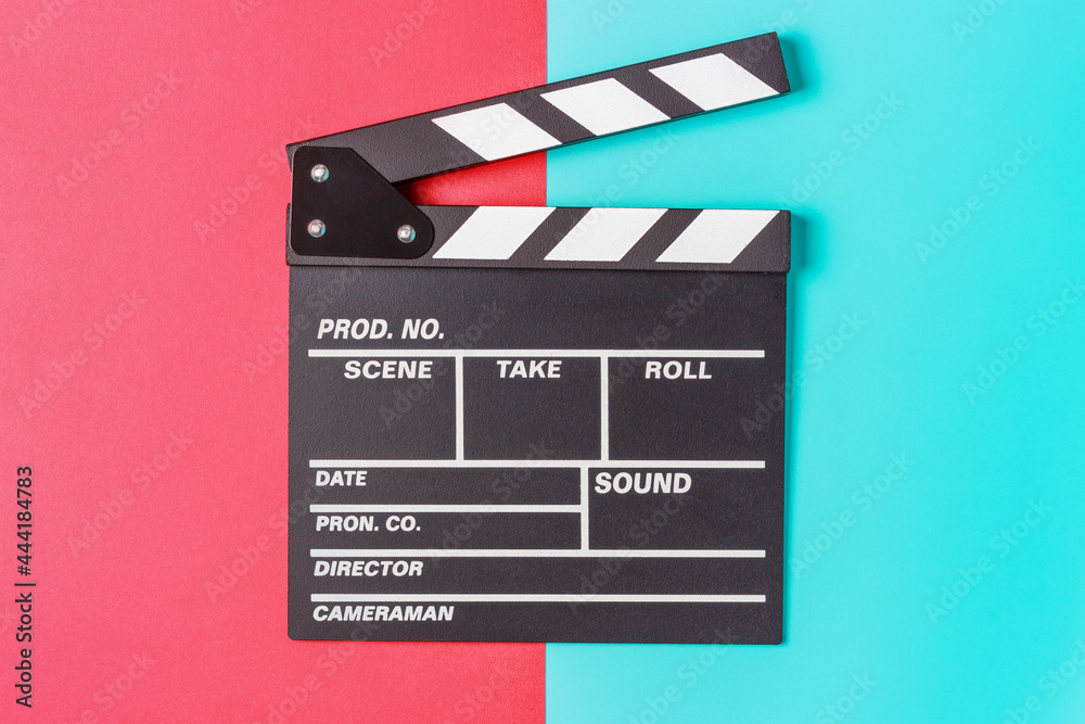 The clapperboard on blue and red background close-up, top view.