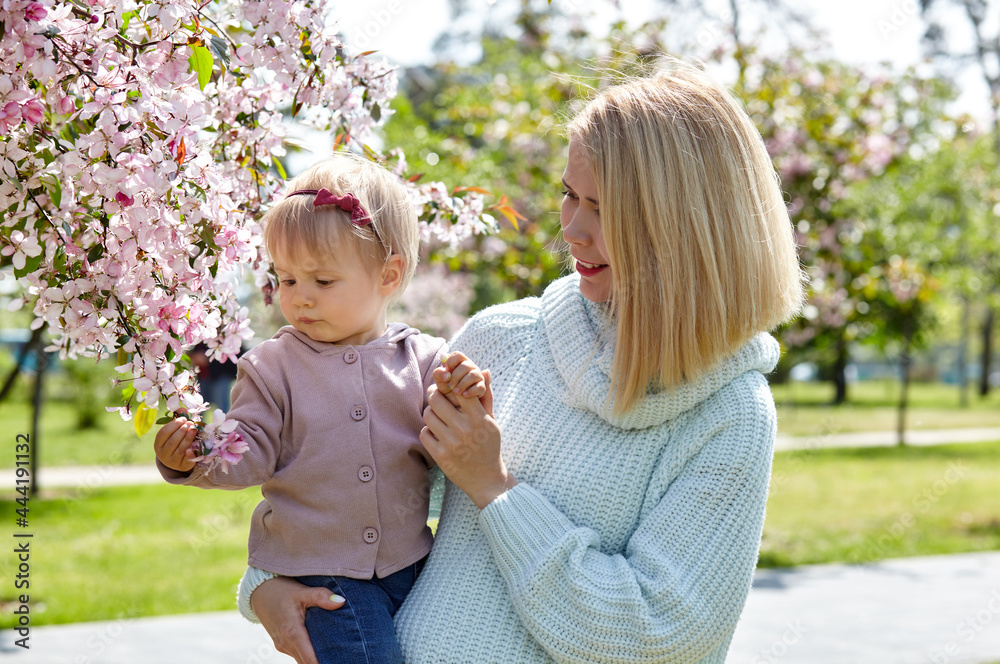 Mom and daughter on nature walk at spring park. Little girl and mother have a good time on weekend activity Mom and daughter on nature walk at spring park. Little girl and mother have a good time on weekend activity