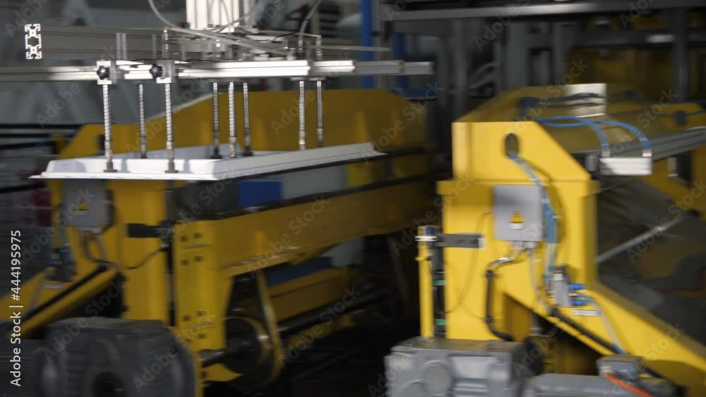 Manipulator of modern machine tool carries plastic part of refrigerator door along spacious production plant workshop Manipulator of modern machine tool carries plastic part of refrigerator door along spacious production plant workshop