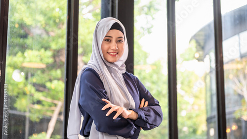 Obraz na plátne Portrait photo of young beautiful Asian Muslim woman wearing hijab standing indoor with confident expression