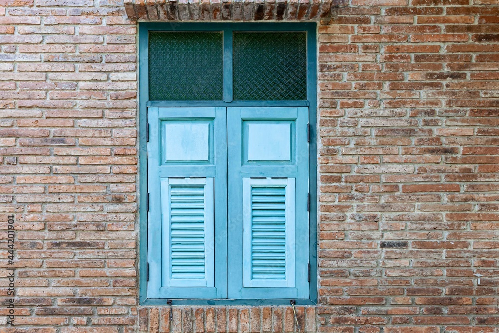 European antique blue wooden shutters window and brown stone brick wall European antique blue wooden shutters window and brown stone brick wall