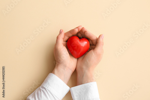 Fototapeta Naklejka Na Ścianę i Meble -  Female hands with red heart on color background