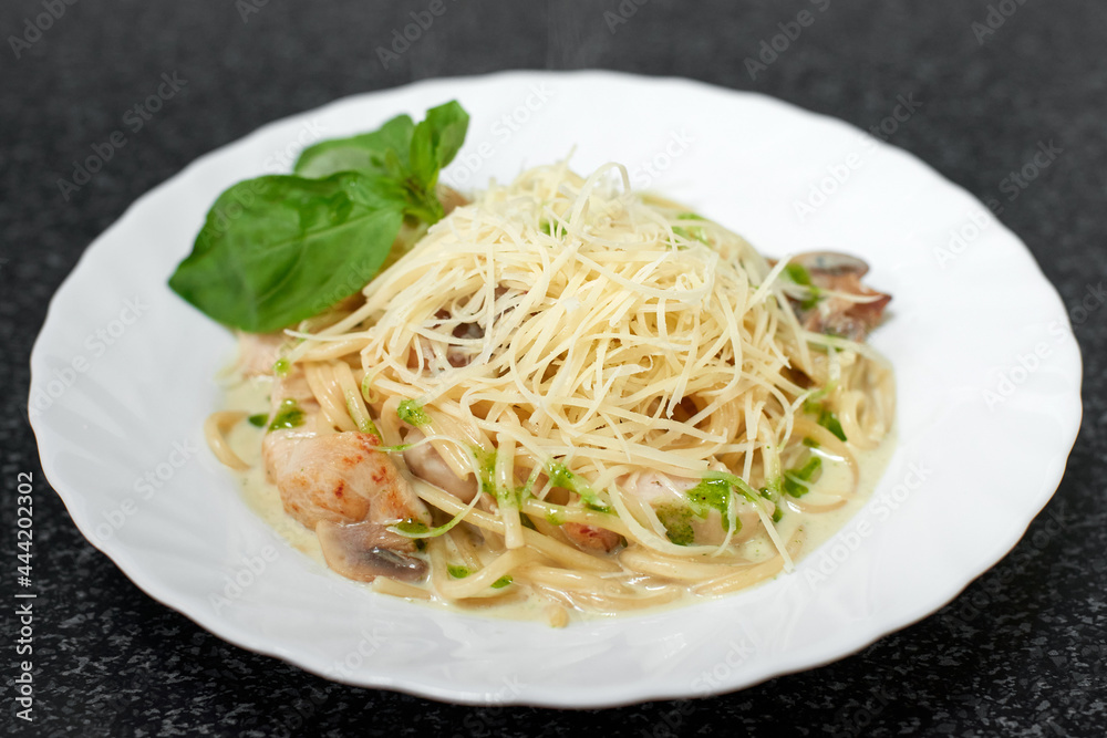 Spaghetti with chicken, mushrooms and cheese in a creamy sauce